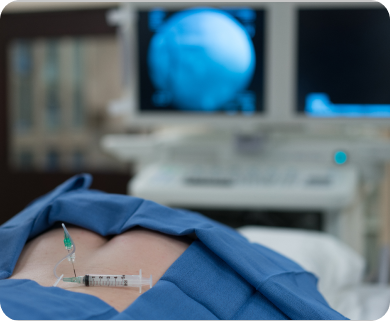 Close-up of ultrasound-guided injection treatment for spinal pain, with a needle in the patient's back and an ultrasound monitor in New York City